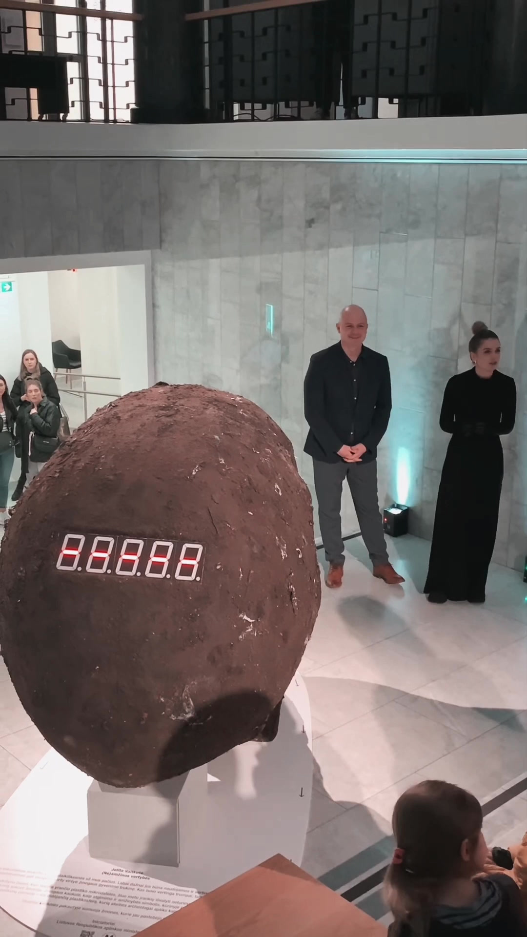 Concrete egg exhibit with an LED counter in a marble hall