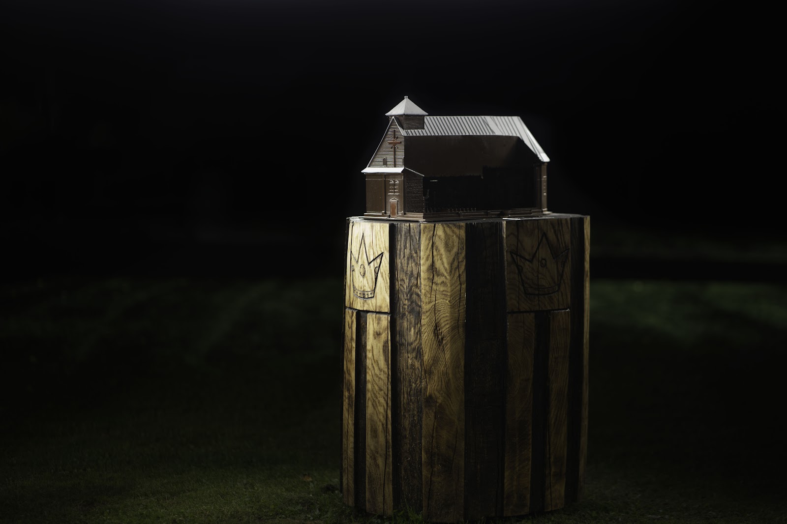 A wooden model of an Inturkė heritage site, lit at night